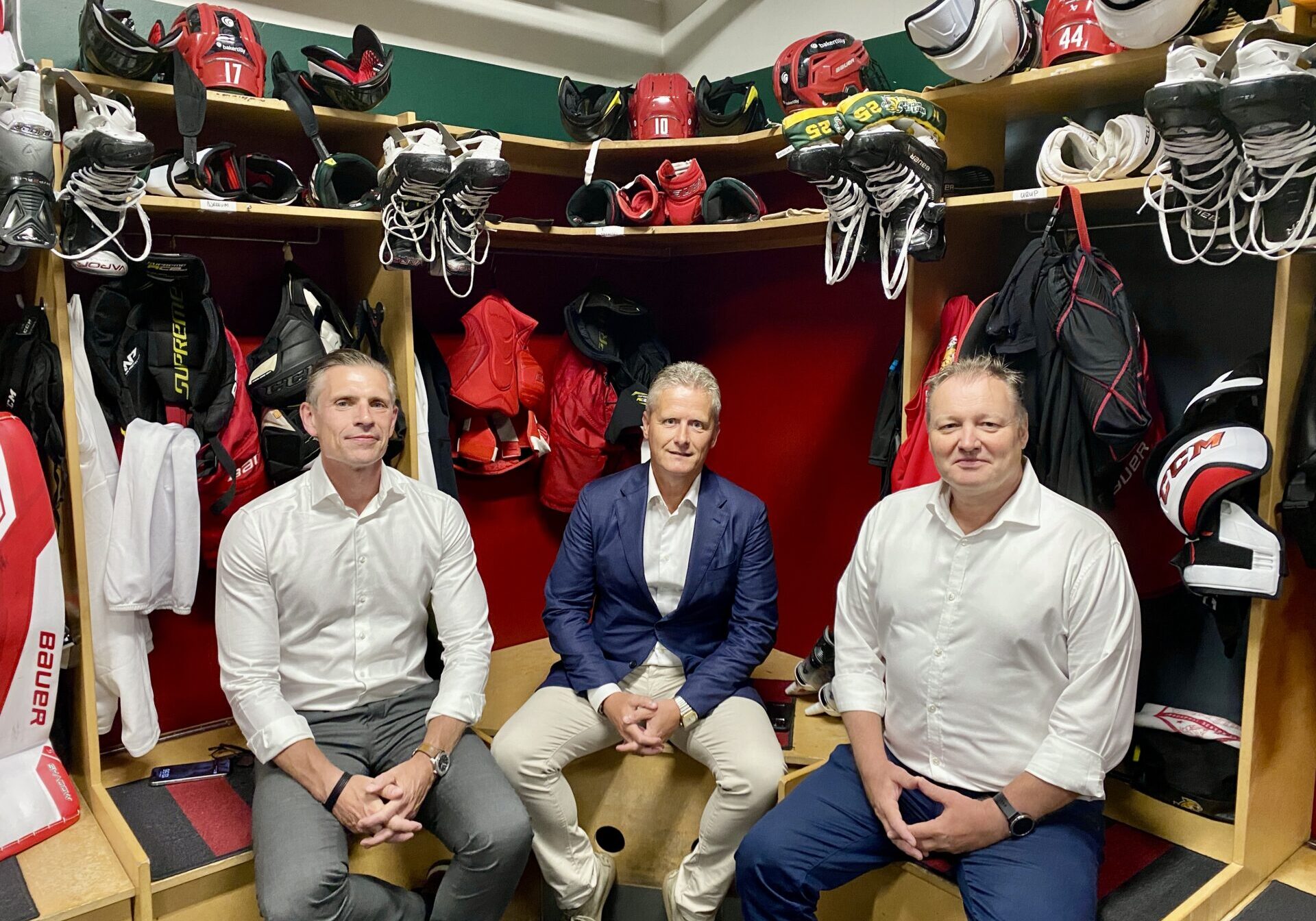 Niels Wegener, Frederik Barfoed og Ole Nielsen fra Barfoed Group siddende i Odense Bulldogs' ishockey-omklædningsrum